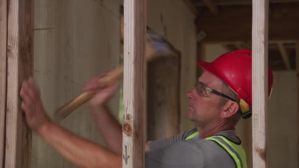 Bauarbeiter Nagelt Mauerstollen — Stockvideo