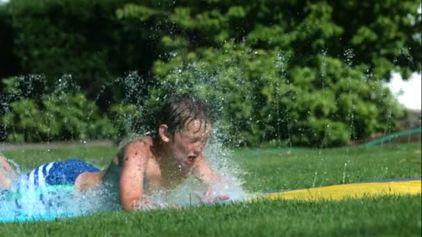 Jonge Jongen Waterglijbaan Slow Motion Neergeschoten Met Een Phantom Camera — Stockvideo