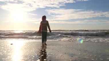 Kumsalda koşan iki çocuk.