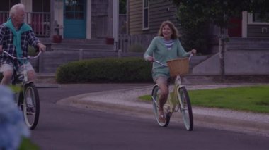 Yaşlı çift birlikte bisiklete biniyor.