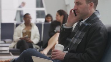 Havaalanında cep telefonuyla konuşan bir iş adamı.
