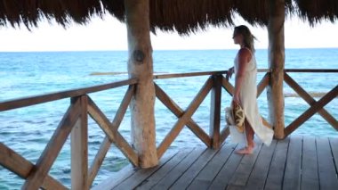 Tropik tatil köyündeki iskelede dikilen kadın