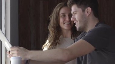 Genç kadın ve erkek kafede selfie çekiyorlar.