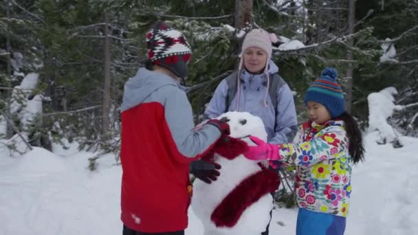 Mor Barn Bygger Snømann Sammen – stockvideo