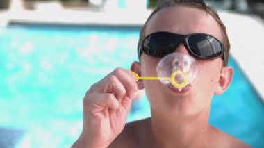 Çocuk çok yavaş çekimde kabarcıklar çıkarıyor.