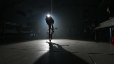Bmx binici karanlık depoda hile yapıyor.