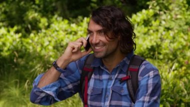 Yürüyüş sırasında cep telefonuyla konuşan adam.