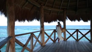 Tropik tatil köyündeki iskelede dikilen kadın