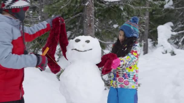 Kaksi Lasta Rakentaa Lumiukko Yhdessä — kuvapankkivideo