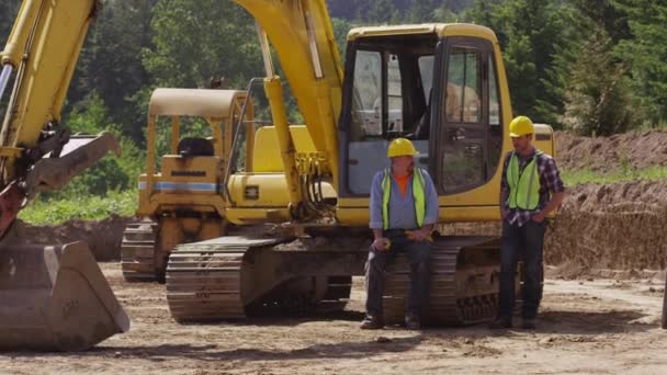 Dos Trabajadores Cuello Azul Hablando Por Maquinaria Excavación — Vídeo de stock