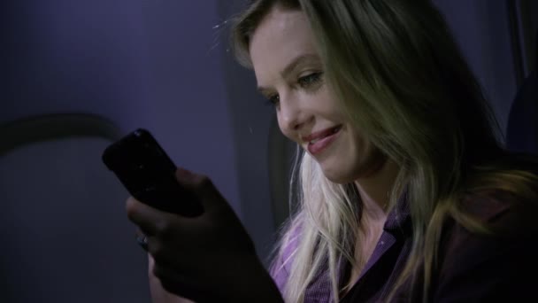 飛行機の中で夜に携帯電話を使っている若い女性の閉鎖 — ストック動画