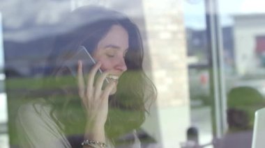 Kafede dizüstü bilgisayarda çalışan bir iş kadını.