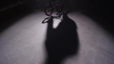 Bmx binici karanlık depoda hile yapıyor.