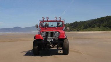 4x4 plajda araba kullanan bir çift.