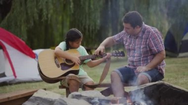 Yaz kampındaki çocuklar kamp ateşi etrafında.