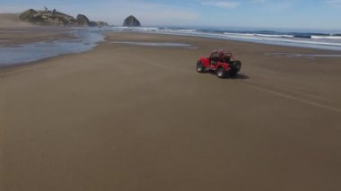 Sahilde giden 4x4 off road aracının hava görüntüsü.