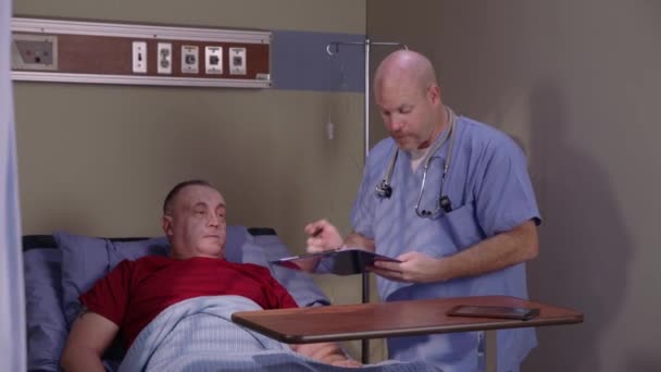 Чоловіча Медсестра Перевіряє Старшого Чоловіка Лікарняному Ліжку — стокове відео