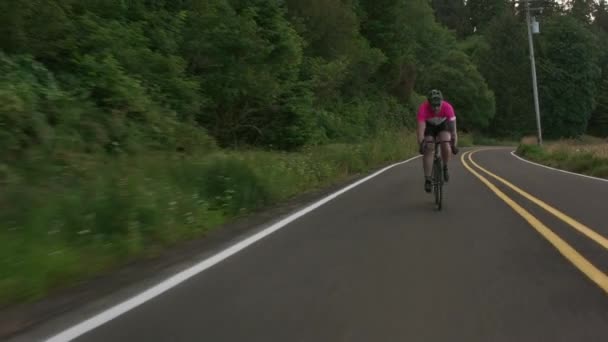 田舎道で男のサイクリストの追跡ショット 商用利用のために完全リリース — ストック動画
