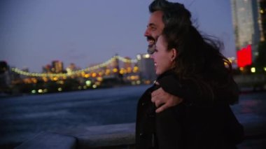 New York 'ta bir çift gece iskelede dikiliyor ve arka planda gökyüzü var.