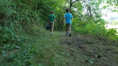 İki erkek balıkçılık dişli ile ormanda yürüyüş