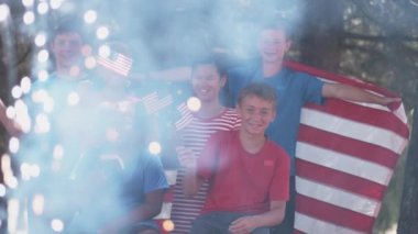 Çocuklar 4 Temmuz 'da havai fişek izleyip bayrak sallıyor.