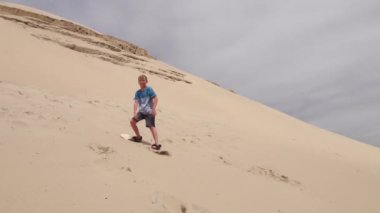 Oregon 'da erkekler kum tepelerinde kayıyor.