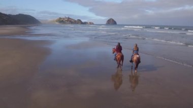 Kumsalda ata binen kadınların hava manzarası.