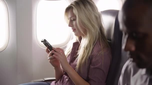 Νεαρή Γυναίκα Που Χρησιμοποιεί Κινητό Τηλέφωνο Στην Πτήση Του Αεροπλάνου Βίντεο Κλιπ