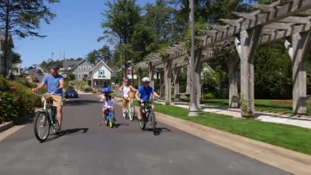 Family Riding Bicycles Together Coastal Vacation Community — Stock Video