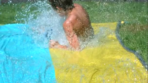 Jonge Jongen Waterglijbaan Slow Motion Neergeschoten Met Een Phantom Camera — Stockvideo