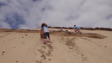 Oregon 'da erkekler kum tepelerinde kayıyor.