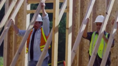 Duvarda ayakta duran bir grup inşaat işçisi