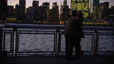 New York 'ta bir çift gece iskelede dikiliyor ve arka planda gökyüzü var.