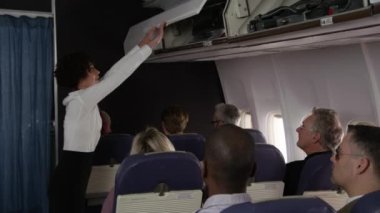 Uçuş görevlisi kalkmaya hazır yolcularla konuşuyor.