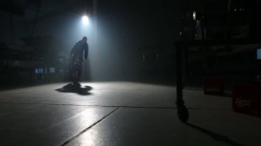 Bmx binici karanlık depoda hile yapıyor.