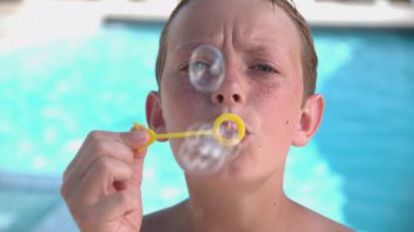 Çocuk çok yavaş çekimde kabarcıklar çıkarıyor.