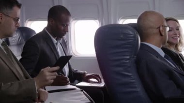 Uçak uçuşunda çalışan iş adamları.