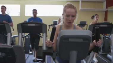 Kadın spor salonunda çalışıyor.