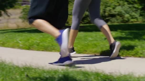 公園を走ってるカップル足を閉じて — ストック動画