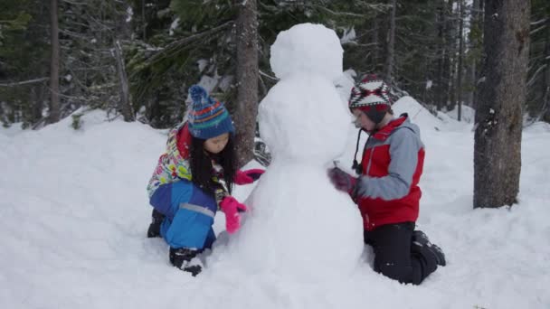 Zwei Kinder Bauen Gemeinsam Schneemann — Stockvideo