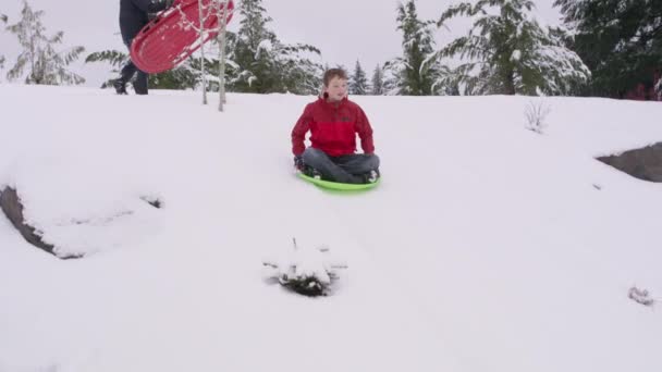 冬天的时候 男孩在雪地上滑行 — 图库视频影像