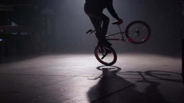 Bmx binici karanlık depoda hile yapıyor.