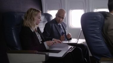 Uçak uçuşunda çalışan iş adamları.