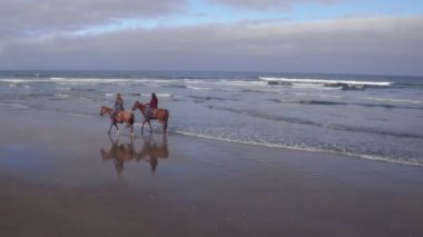 Kumsalda ata binen kadınların hava manzarası.