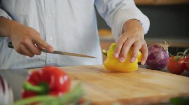 Sarı dolmalık biber kesen adamı yakından çek.