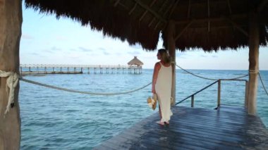 Tropik tatil köyündeki iskelede dikilen kadın
