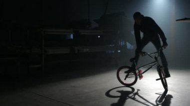 Bmx binici karanlık depoda hile yapıyor.