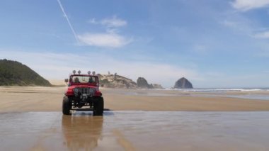 4x4 plajda araba kullanan bir çift.