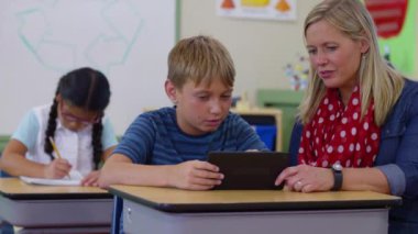 Öğretmen ve öğrenci okulda dijital tablet kullanıyorlar.