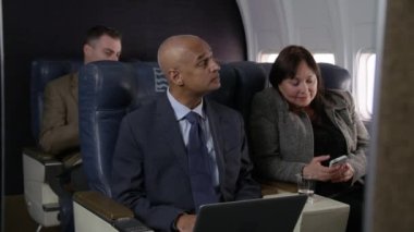 Uçak uçuşunda çalışan iş adamları.